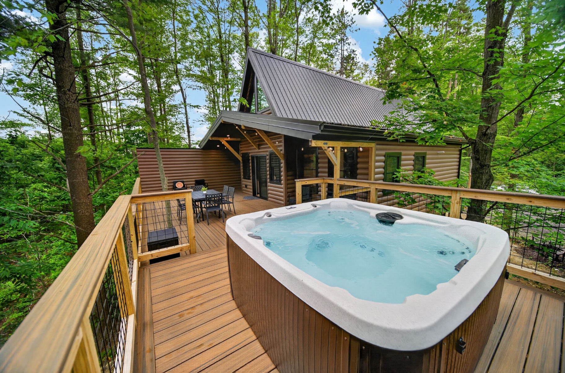 Private hot tub on a treehouse deck in the summer forest